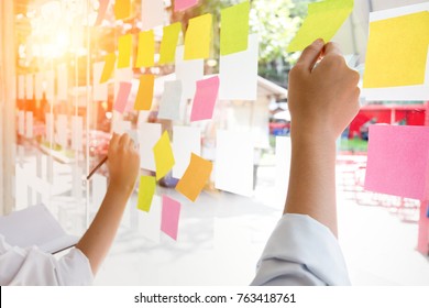 Business People Post It Notes In Glass Wall At Meeting Room