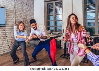 Business people pulling rope in office, funny teambuilding activity. - Shutterstock ID 1611361858