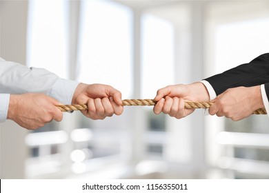 Business People Pulling Rope In Opposite Directions