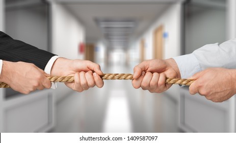 Business people pulling rope in opposite directions at office - Shutterstock ID 1409587097