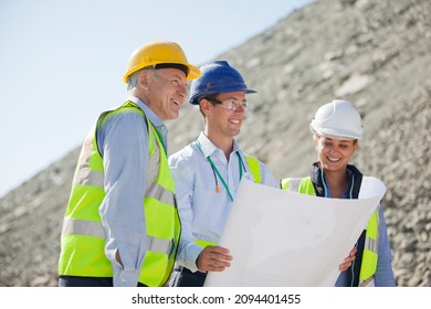 Business People Reading Blueprints In Quarry