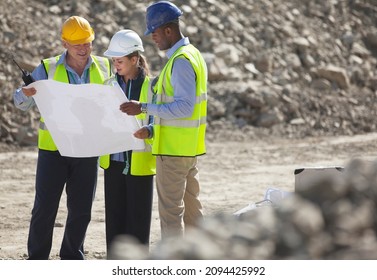 Business People Reading Blueprints In Quarry