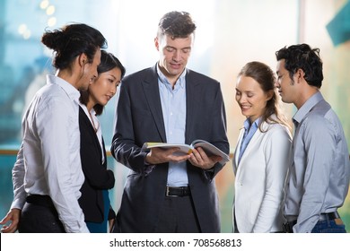 Business People Reading Book Together