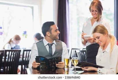 Business people reading menu and ordering in a restaurant