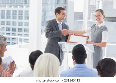 Business people receiving award in meeting room