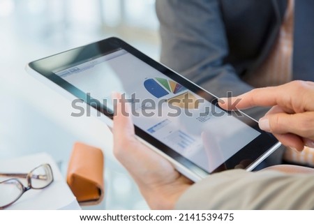 Business people reviewing financial data on digital tablet