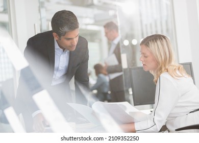 Business People Reviewing Paperwork In Conference Room