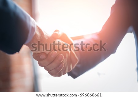 Business people shaking hands, finishing up meeting. Successful businessmen handshaking after good deal.