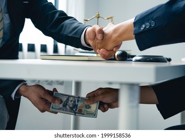 business people shaking hands and Give an under-the-table bribe to an attorney to help a lawyer win a court case. Bribery and Kickback Ideas Fraud and Fraud - Shutterstock ID 1999158536