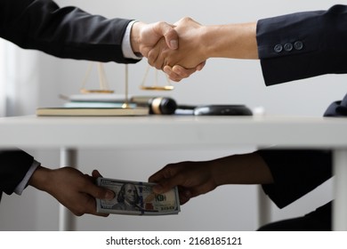 Business people shaking hands and Give an under-the-table bribe to an attorney to help a lawyer win a court case. Bribery and Kickback Ideas Fraud and Fraud - Shutterstock ID 2168185121