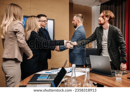 Business people shaking hands in the meeting room, preparing for the conference, cooperation with clients, shareholders planning a partnership deal in the corporate office.
