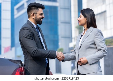 Business people shaking hands outside office building