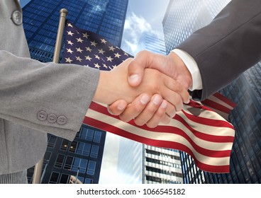 Business people shaking their hands against american flag and skyscraper - Powered by Shutterstock