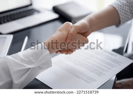 Business people signing contract papers while sitting at the glass table in office, closeup. Partners or lawyers working together at meeting. Teamwork, partnership, success concept.