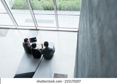 Business People Sitting In Lobby And Discussing Business Strategy, View From Above