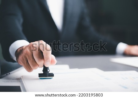 business people stamp On the contract documents at the desk, the concept of confirmation or approval of the agreement, the application authorization authority, the bank loan documents through support.