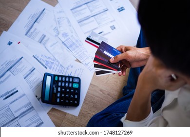 Business people are stressed about credit card debt and many bills on the floor. Men get trouble by calculating monthly expenses and then budgeting not enough money for paying debts.  