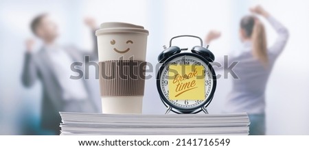 Business people taking a break in the office, alarm clock with sticky note in the foreground