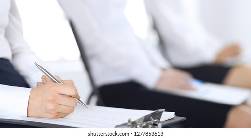 Business people taking part at conference or training at office, close-up. Women sitting on chairs and making notes like at queue or meeting  - Shutterstock ID 1277853613