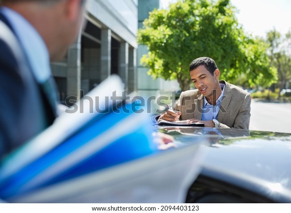 Business people talking at\
car