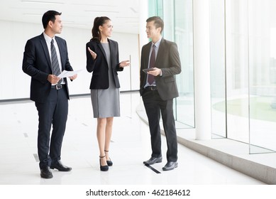 Business People Talking And Discussing Work In Building Hallway