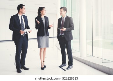 Business People  Talking And Discussing Work In Building Hallway