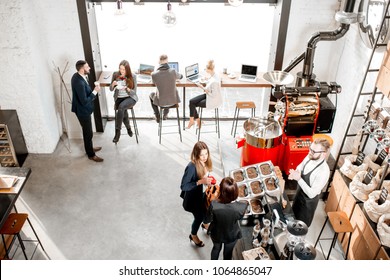 Business people talking and having fun durnig a coffee time in the modern cafe interior. Wide view from above - Powered by Shutterstock