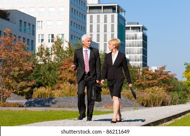 Business People Talking Outdoors And Walking In A Park