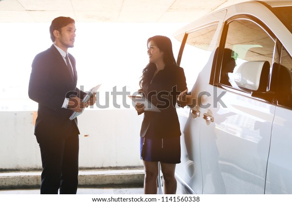 business people\
talking and standing near car\
park