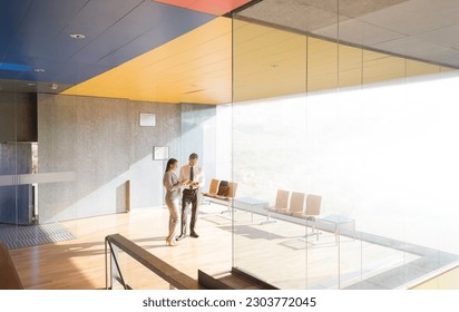 Business people talking in sunny lobby - Powered by Shutterstock