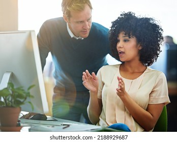 Business people talking, training and discussing a creative strategy working on a desktop computer together in an office at work. Black female employee explaining an idea to a male manager on a pc