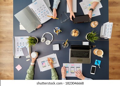 Business, People And Team Work Concept - Team Of Startuppers With Gadgets And Papers Working At Office Table