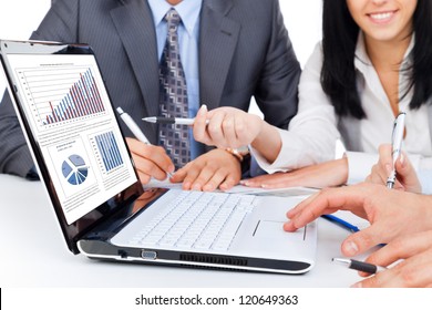 business people team work group during conference report discussing financial diagram, charts, on laptop screen businesspeople meeting sitting at desk office pointing hand finger at graph - Powered by Shutterstock