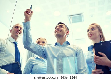 business, people, teamwork and planning concept - smiling business team writing something no notice board with marker in office - Powered by Shutterstock