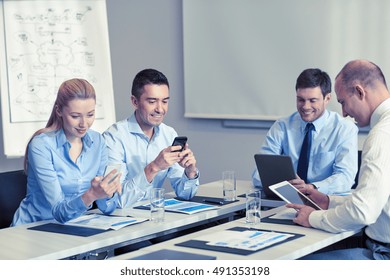 Business-, People- und Technologiekonzept - lächelndes Geschäftsteam mit Smartphone und Papiertreffen im Büro