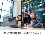 business people technology and teamwork concept - smiling businessman and muslim businesswomen with laptop meeting in cafe