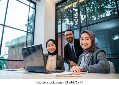 Business People Technology And Teamwork Concept - Smiling Businessman And Muslim Businesswomen With Laptop Meeting In Cafe