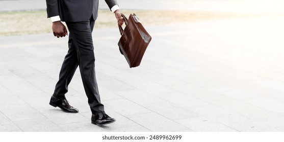 Business People. Unrecognizable Afro Man Walking In Urban Area In Formal Wear With Briefcase. Cropped, Free Space - Powered by Shutterstock