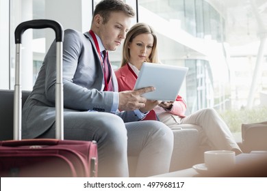 Business People Using Digital Tablet While Sitting At Lobby In Convention Center