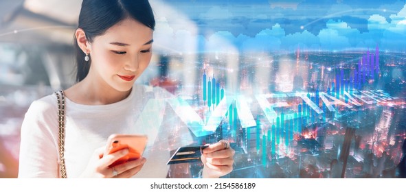 Business People Using Digital Wallet For Pay In Metaverse Concept. Young Adult Asian Woman Consumer Using Creadit Card And Smartphone With City And Financial Graph Background.