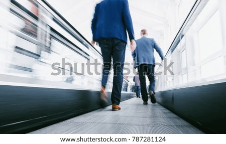 business people using a escalator on a  trade show