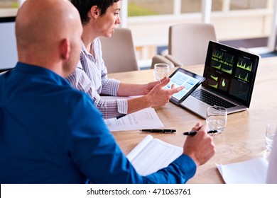 Business people using high tech equipment to analyze vast amounts of data and then represent it graphically on the screen of their tablet and portable computer. - Powered by Shutterstock