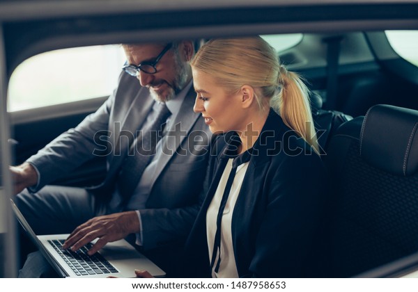 business\
people using laptop computer at backseat of\
car