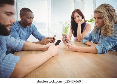 Business People Using Technology At Desk In Office