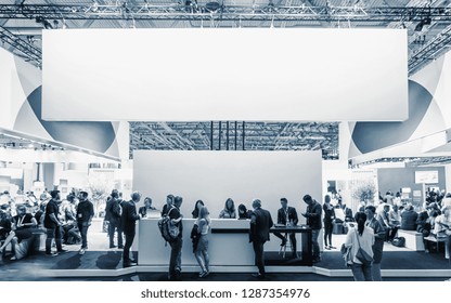business people walking between trade show booths at a public event exhibition hall, with banner and copy space for individual text
