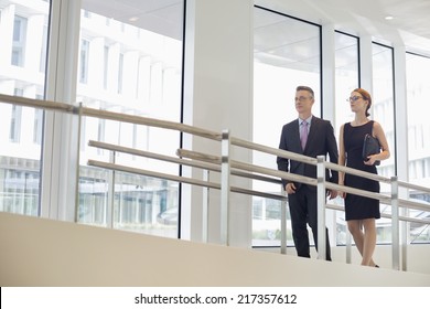 Business People Walking By Railing In Office