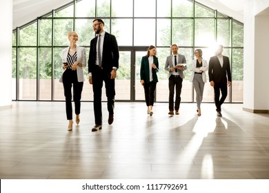 Business People Walking Forward And Talking Together At The Modern Office Hall Indoors