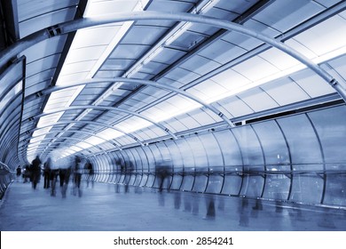 Business People Walking In A Futuristic Tunnel. Shot With Slow Shutter Speed To Create Blur Effect