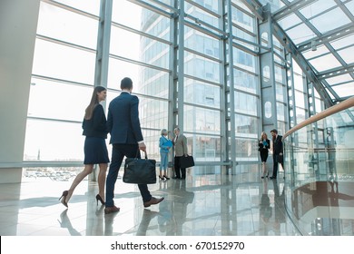 Business people walking in modern glass office building