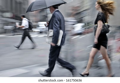 business people walking in the street on a rainy day motion blurred - Shutterstock ID 161750636
